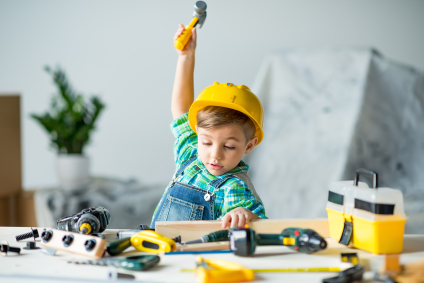 Little boy with tools Cute little boy in yellow hard hat holding wooden plank and toy hammer