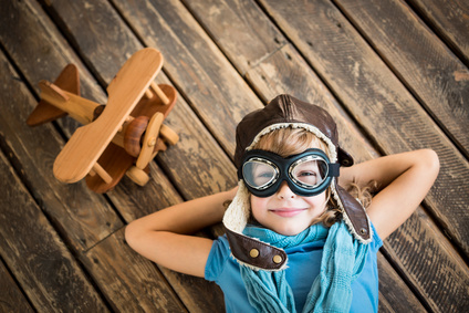 Dream Child pilot with vintage plane toy on grunge wooden background